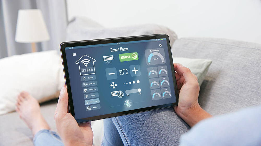 a young man holding a tablet to control smart home - feature - Smart Homes